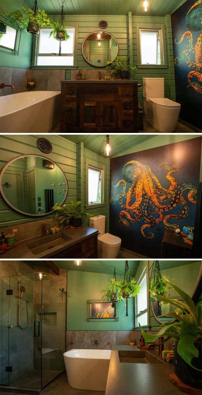Bathroom corner decorated with green walls, hanging plants, wooden vanity, and an octopus mural on the wall.