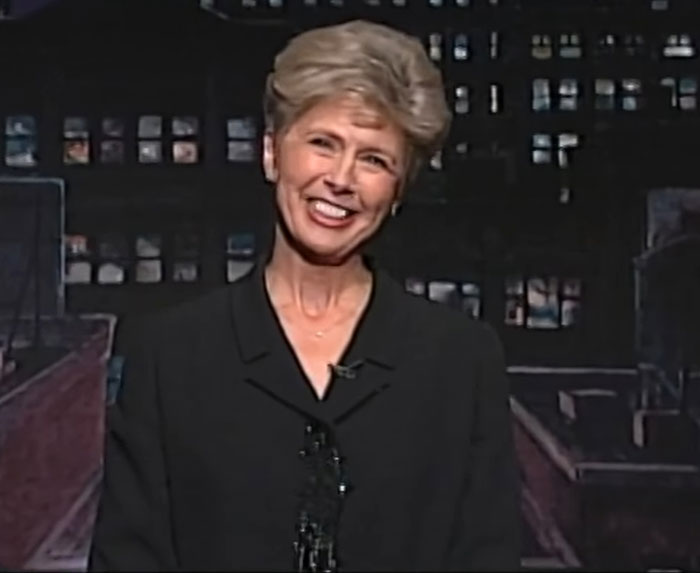 Smiling woman in formal black attire speaking in a dimly lit studio, related to Brad Pitt final public message viral news. Smiling woman in formal black attire speaking in a dimly lit studio, related to Brad Pitt final public message viral news.