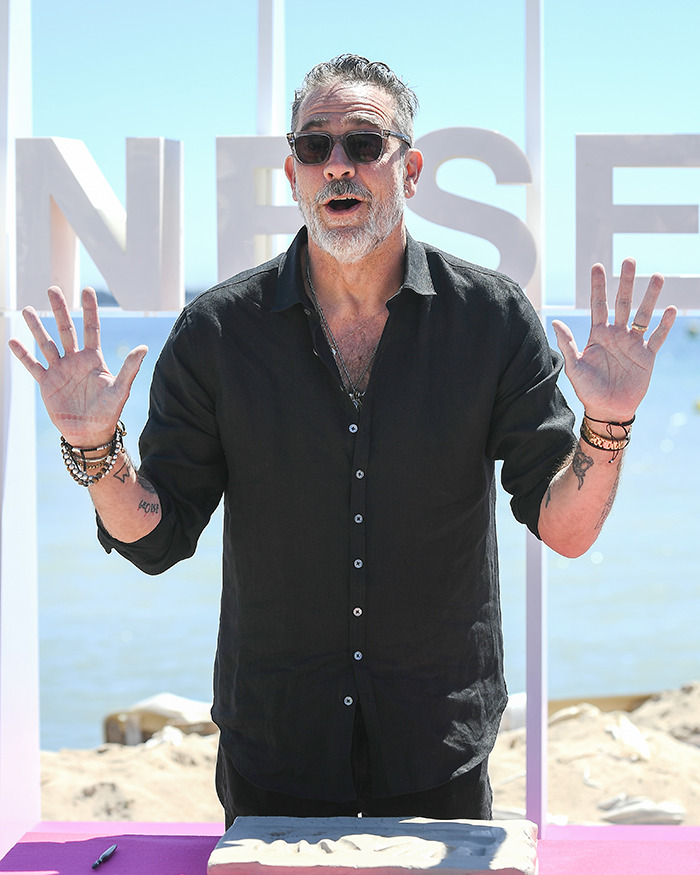 Jeffrey Dean Morgan in black shirt and sunglasses at outdoor event, responding to viral theory about his habits.
