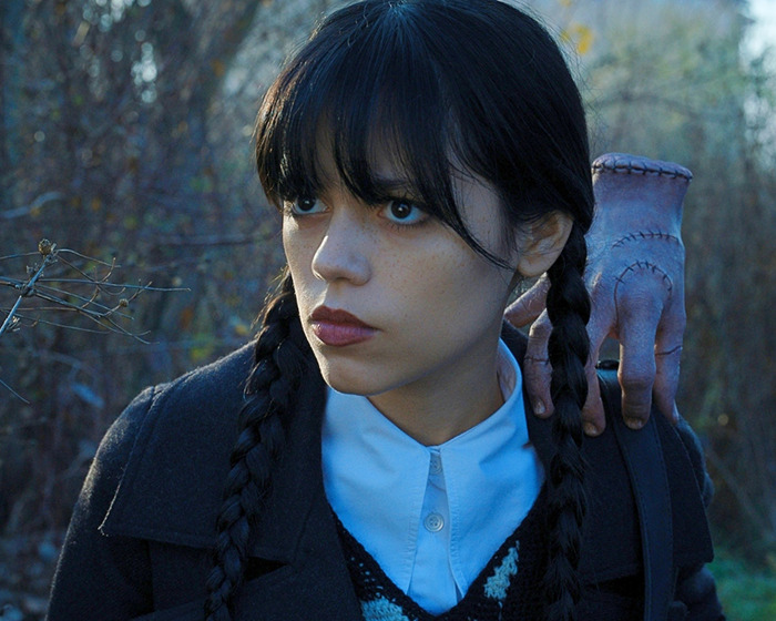 Young woman with braided hair and tired girl beauty trend makeup, outdoors with an eerie hand on her shoulder.