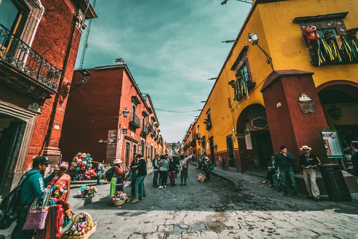 Colorful street scene with people and vendors, capturing moments of good news and lively community life outdoors.