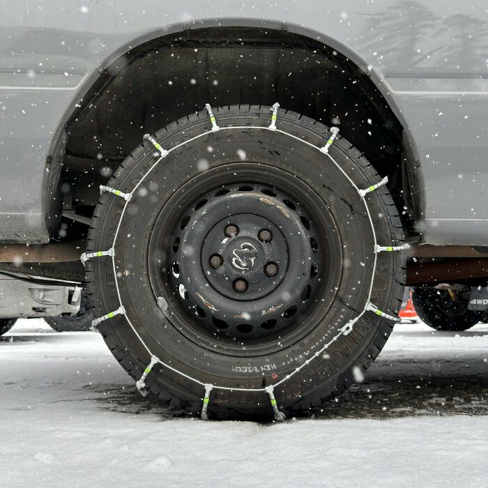 Tire with snow chains on a vehicle in snowy weather, illustrating unexpected items like a coffin on wedding registries.