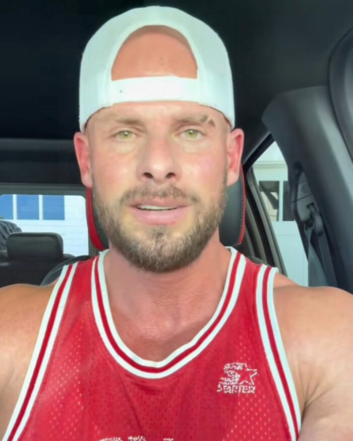 Joey Swoll in a red tank top and white cap giving a direct message, praised for takedown in male height debate.