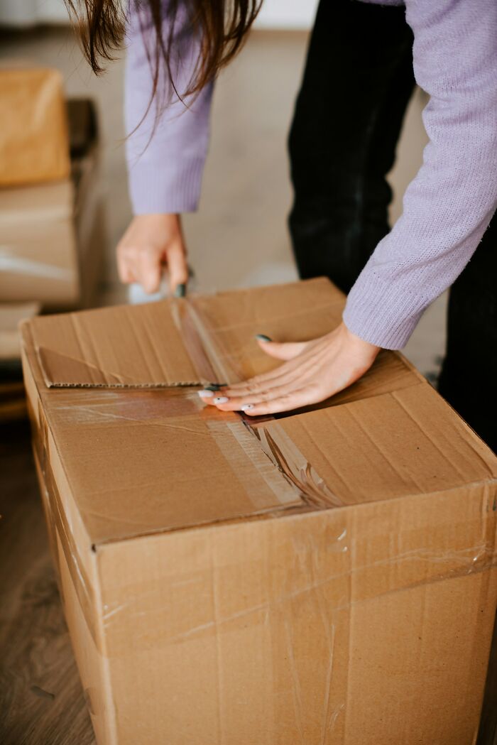 Person opening a cardboard box, illustrating moments people actually experienced psychic predictions coming true.