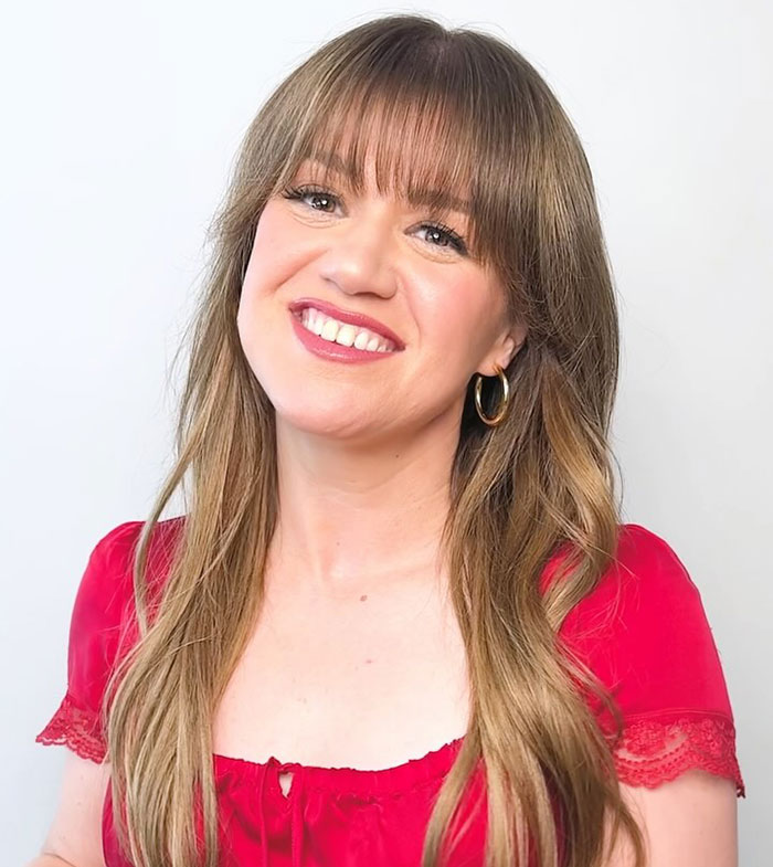 Kelly Clarkson smiling in a red blouse with hoop earrings, reflecting emotions after messy painful divorce and ex’s passing. Kelly Clarkson smiling in a red blouse with hoop earrings, reflecting emotions after messy painful divorce and ex’s passing.