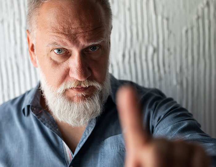 Close-up of a serious older man with a beard, symbolizing survivors sharing horrifying kidnapping experiences.