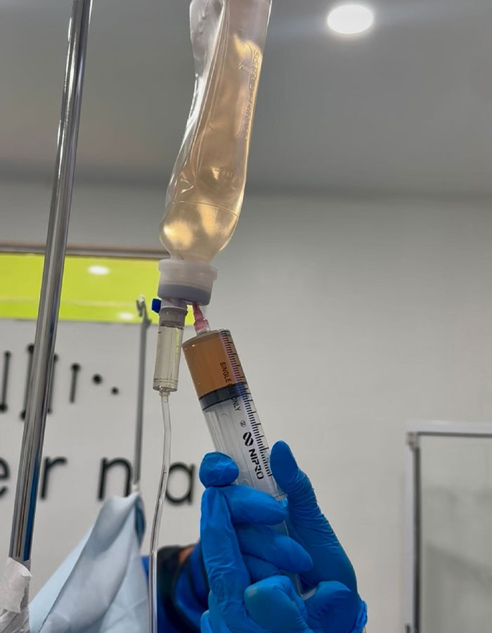 Close-up of gloved hands preparing IV fluids in a medical setting related to Kim Kardashian Mexico procedure. Close-up of gloved hands preparing IV fluids in a medical setting related to Kim Kardashian Mexico procedure.