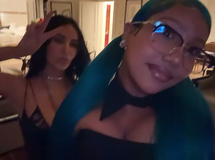 Kim Kardashian and her daughter North West in a dimly lit room, highlighting the controversial corset fashion choice.