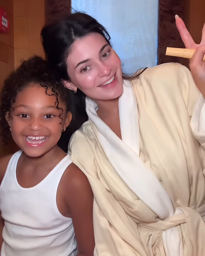 Kylie Jenner and daughter Stormi smiling together in a cozy setting, promoting mom&rsquo;s latest cosmetics ad.