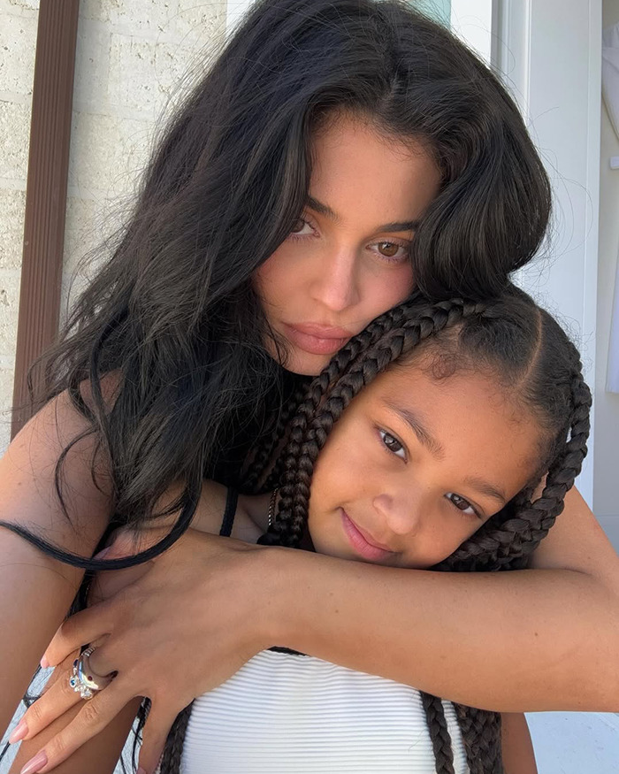 Kylie Jenner with daughter Stormi in a close embrace, showcasing family bond in latest cosmetics ad campaign.