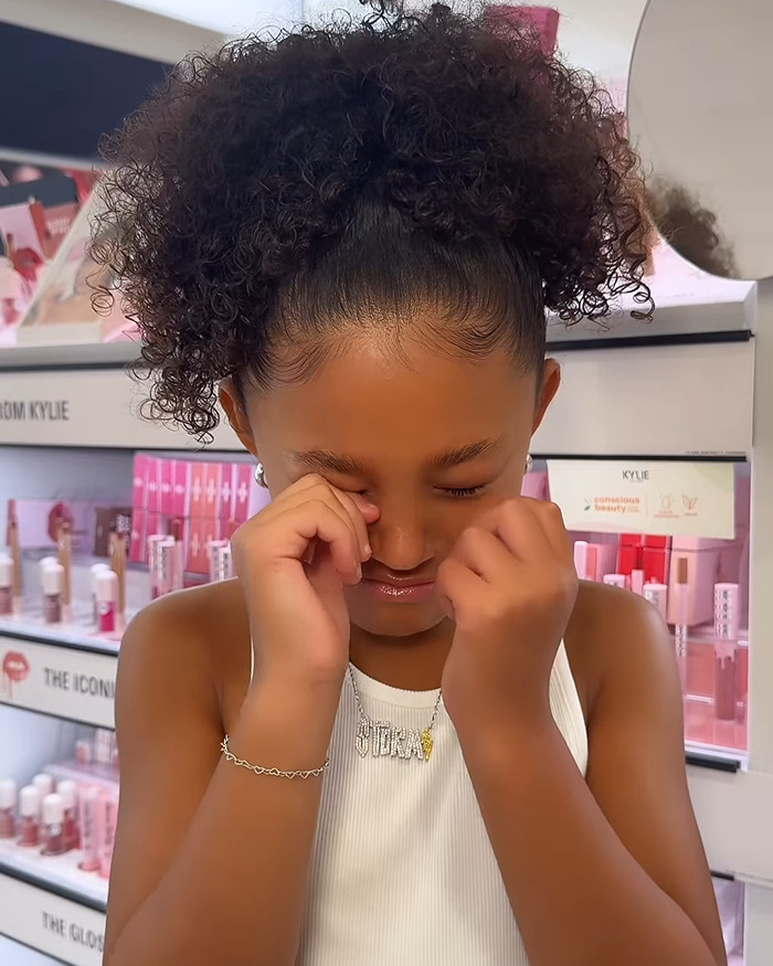 Stormi Jenner with curly hair in a cosmetics store, highlighting Kylie Jenner&rsquo;s daughter in latest beauty ad campaign.