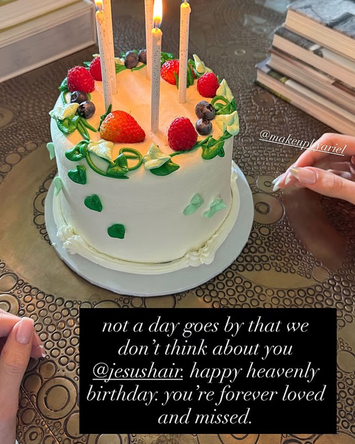 Birthday cake with strawberries, blueberries, and candles, highlighting Kylie Jenner's daughter Stormi in cosmetics ad spotlight.