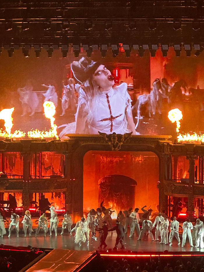 Lady Gaga performing on stage with fiery background, amid backlash over ageist and misogynistic comments at concert. - 11