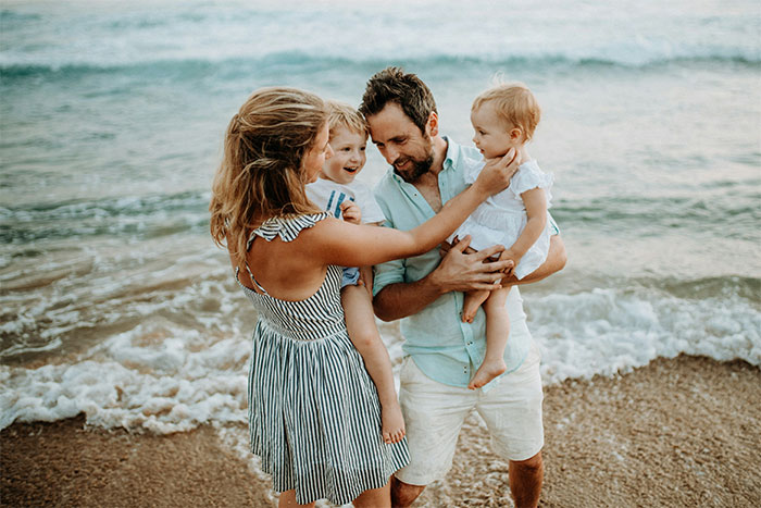 Family on beach during vacation, showing wife leaving man-child husband while spending time with children by the sea.
