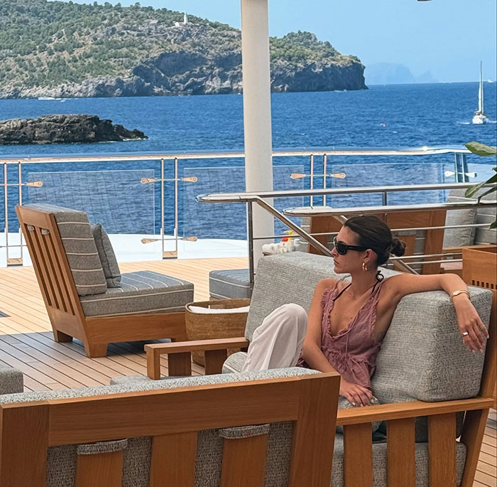 Woman relaxing on a yacht during Leonardo DiCaprio's PDA-filled yacht trip by the sea with scenic island views.