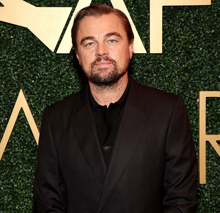 Leonardo DiCaprio attending an event, dressed in a black suit, related to his PDA-filled yacht trip with girlfriend.