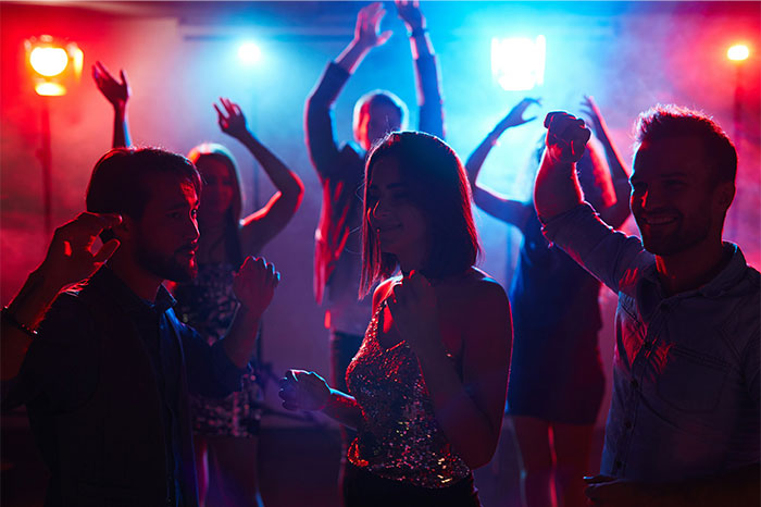 People dancing at a party with colorful lights, capturing the energy and atmosphere of a lively Boston Marathon event celebration. - 29
