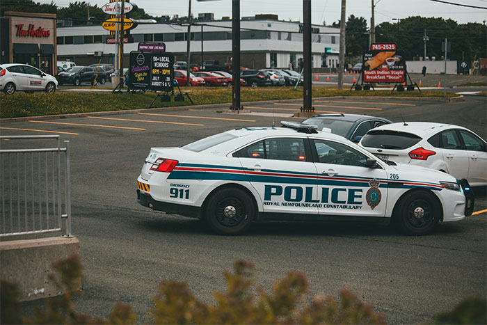 Police car parked in a public lot near businesses, illustrating safety and guardian angel presence at the Boston Marathon. - 8