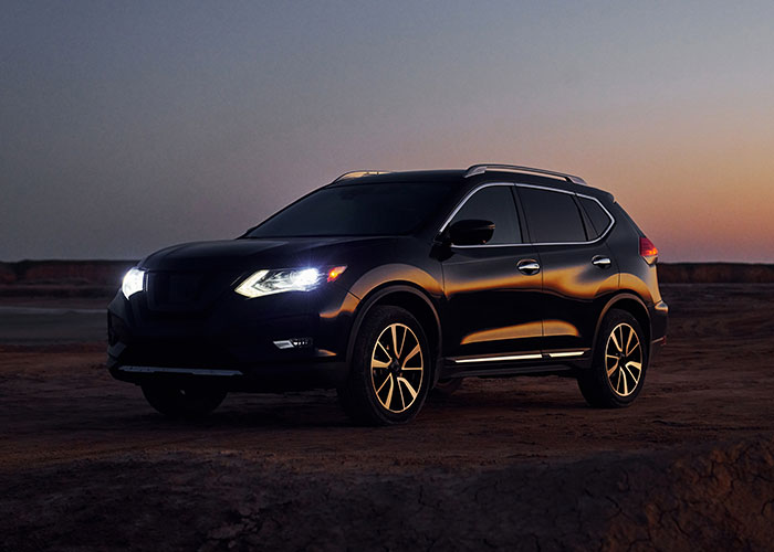 Black SUV with headlights on parked at dusk on a deserted dirt road, hinting at terrifying road encounters shared by truck drivers.
