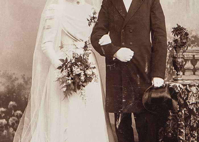 Vintage sepia photo of a bride and groom standing side by side, highlighting a classic wedding portrait style.