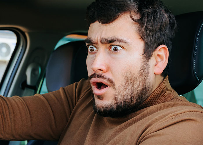 A truck driver showing a terrified expression while driving, illustrating terrifying road encounters and nightmares.