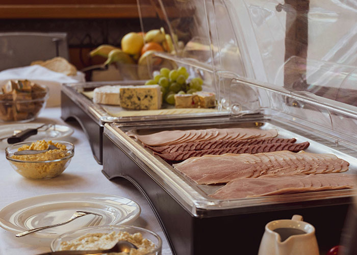 Buffet spread with deli meats, cheeses, fruits, and condiments showcasing creative loopholes used in food presentation.