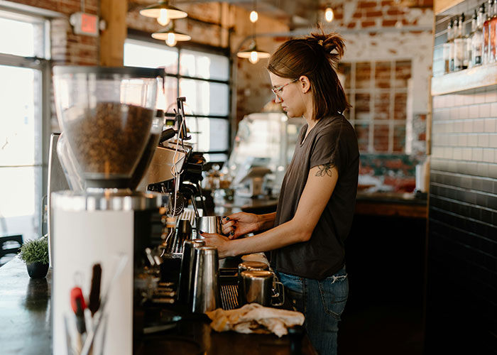 Barista preparing coffee in a rustic cafe, showing a casual moment that reflects discovering loopholes in daily routines.