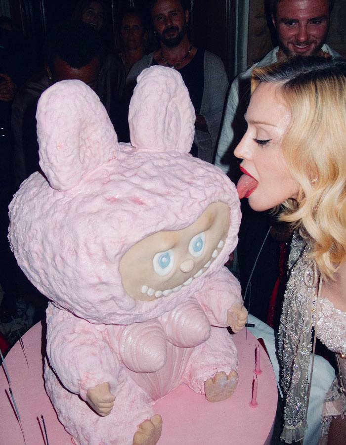 Madonna celebrating with a unique pink cake, embracing cosmetic change advice from her young boyfriend.