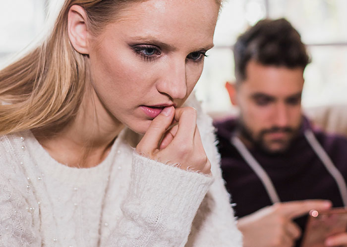 Woman looking worried after finding out boyfriend told friends she couldn&rsquo;t join couples trip without asking her