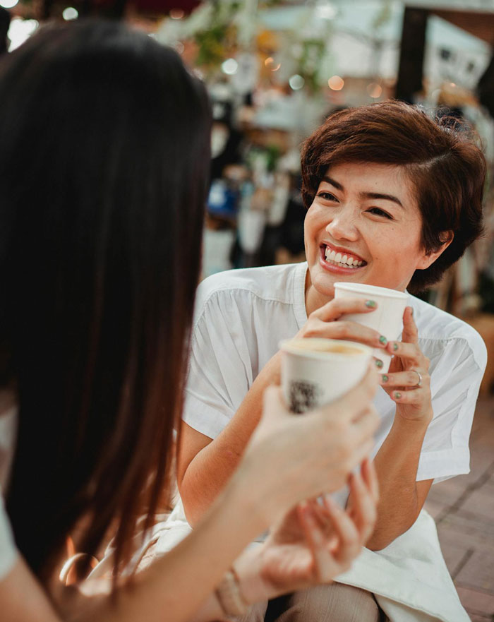 Two women enjoying coffee together in a casual setting, illustrating a story about a friend&rsquo;s boyfriend being tired of financial requests.