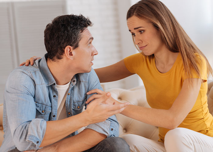 Couple having an emotional conversation about a tattoo, with the woman expressing concern and the man refusing to remove it.