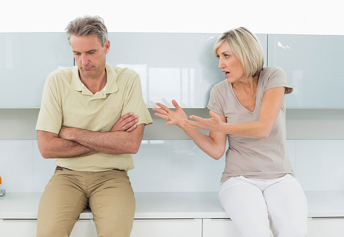 Man and woman arguing in a modern kitchen, illustrating conflict after man&rsquo;s compliment to girlfriend&rsquo;s mom sparks fight.