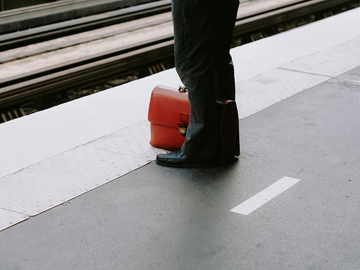 Man standing at train platform with briefcase, symbolizing man promises quiet life with two kids and stepdaughter conflict.