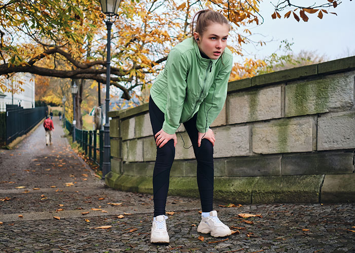 Young woman looking sick and exhausted during outdoor exercise, highlighting risks of doctors getting diagnosis wrong.