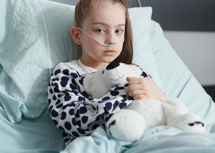A young sick girl in hospital bed with oxygen tube, hugging a stuffed animal, highlighting doctors getting it wrong.
