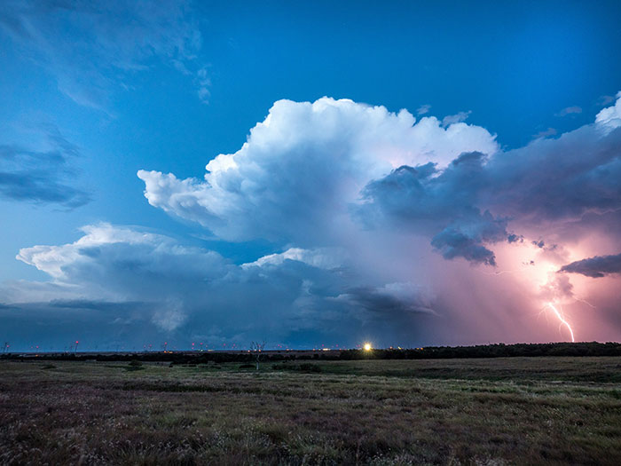 Dark storm clouds with lightning strike over an open field, illustrating a dramatic and smelly sewage disaster scene.