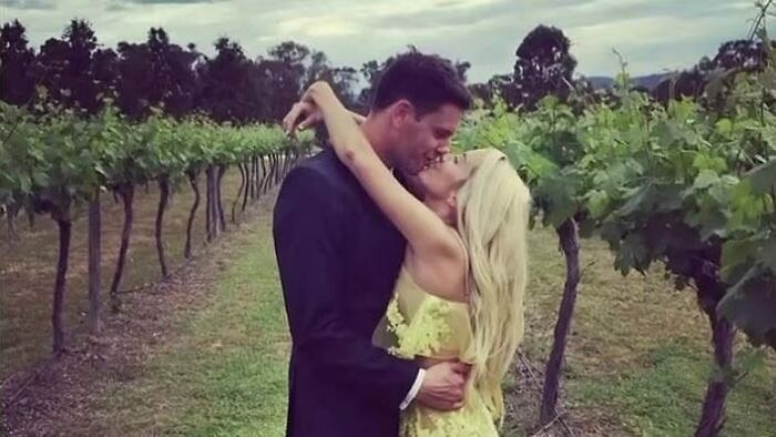 Couple embracing in vineyard, linked to squatting and renovating an abandoned million-dollar house sparking debate.