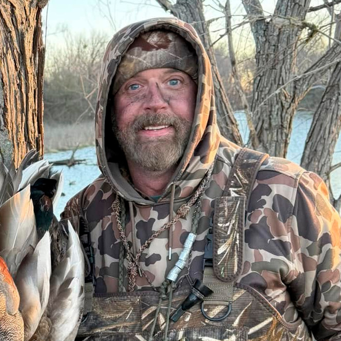 Hombre con ropa de camuflaje cerca de un lago, relacionado con safari de búfalo y cazador millonario. Hombre con ropa de camuflaje cerca de un lago, relacionado con safari de búfalo y cazador millonario.