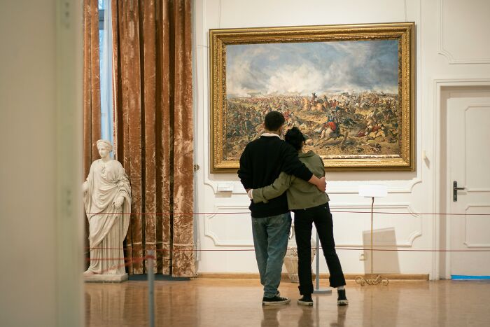 Couple in a museum viewing artwork, illustrating stories from people sharing favorite ways to avoid babysitting online.