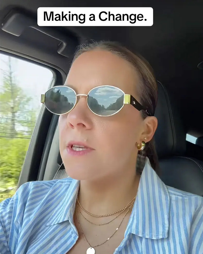 Woman wearing sunglasses and striped shirt inside a car, reflecting a clear sky, themed around depressed mom and family struggles.