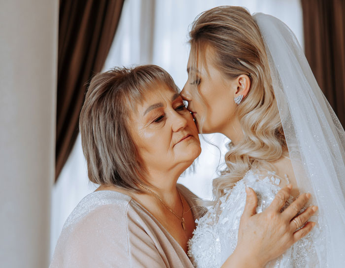 Bride and her mom sharing an emotional moment with the mom threatening to wear a white gown to the wedding event.