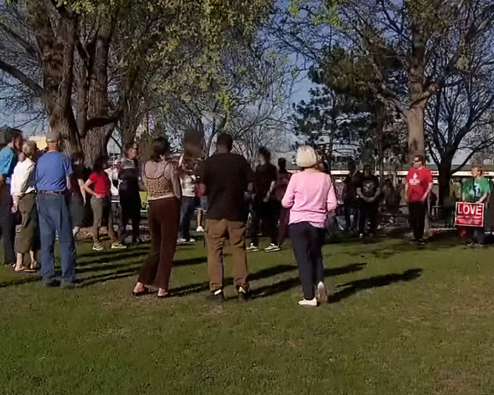 Group of people gathered outdoors in a park, discussing or protesting related to mom who called autistic child racial slur case. Group of people gathered outdoors in a park, discussing or protesting related to mom who called autistic child racial slur case.