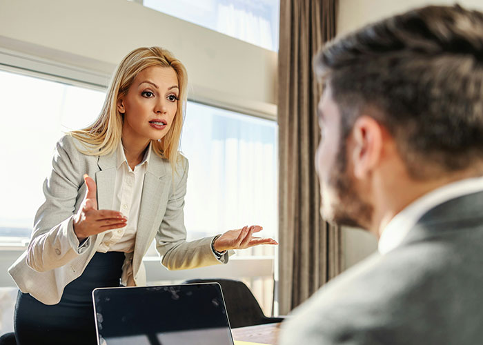 Businesswoman explaining mind tricks to a man during a meeting in a bright office with a laptop on the table. - 28
