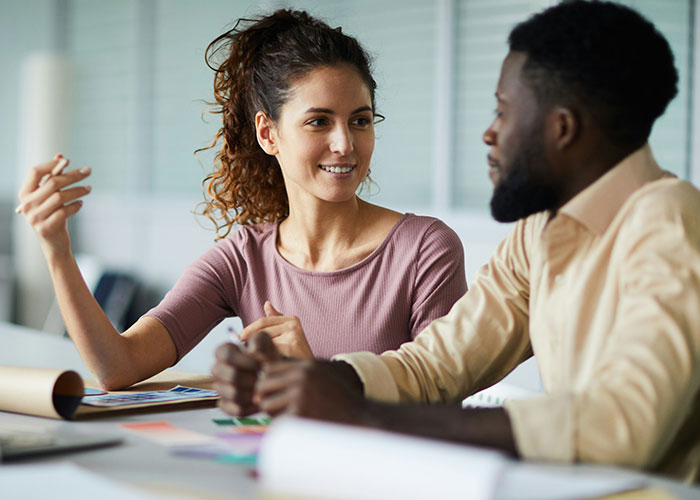 Two colleagues discussing mind tricks that actually work during a casual office meeting with papers on the table. - 22
