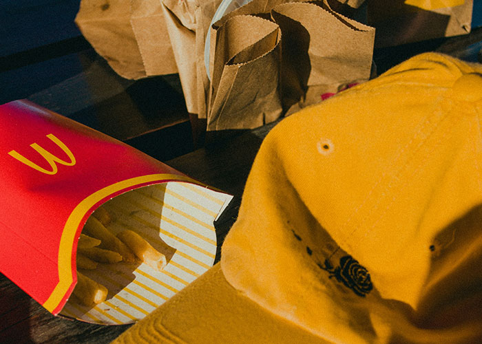 Close-up of fries in a red container next to a yellow cap and brown paper bags, illustrating mind tricks that actually work. - 39