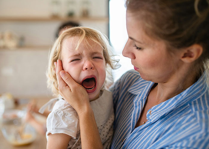 Woman using mind tricks to calm a crying toddler in a home setting, demonstrating effective emotional soothing techniques. - 10
