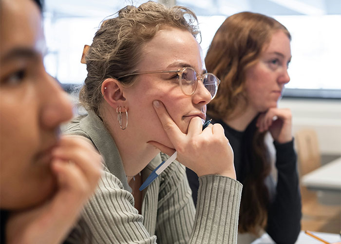 Three people deeply focused in a classroom setting, illustrating concentration and mind tricks that actually work. - 5