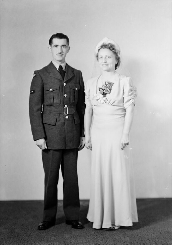 Vintage 1940s wedding photo of a bride in gown and a groom in military uniform capturing love in the shadow of war.