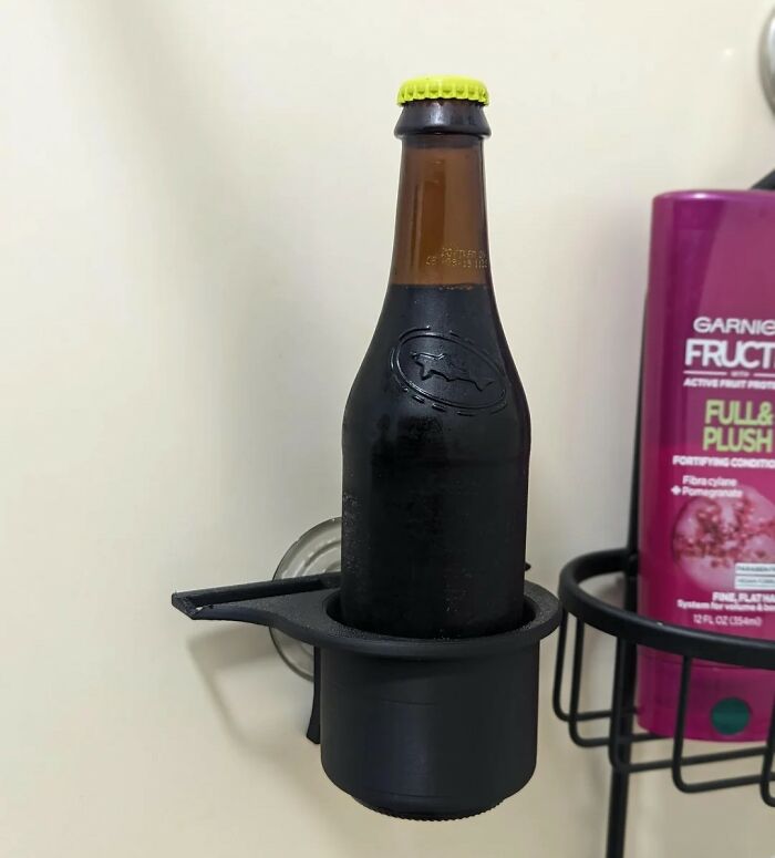 Black bottle with a yellow cap placed in a wall-mounted cup holder, showcasing unique wedding registry ideas.