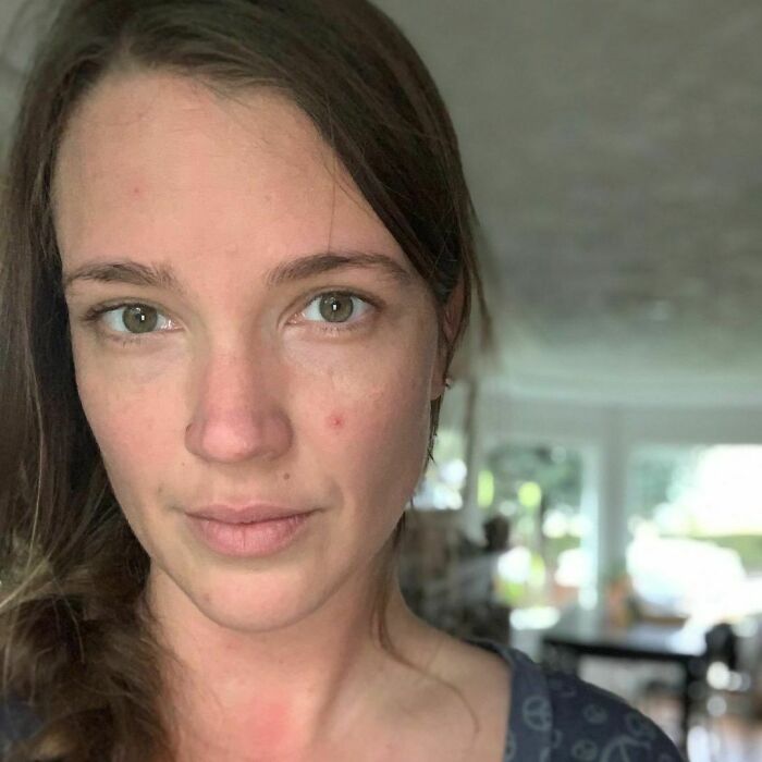 Close-up of a woman with a neutral expression, highlighting the theme of obsession with her therapist in the background setting.